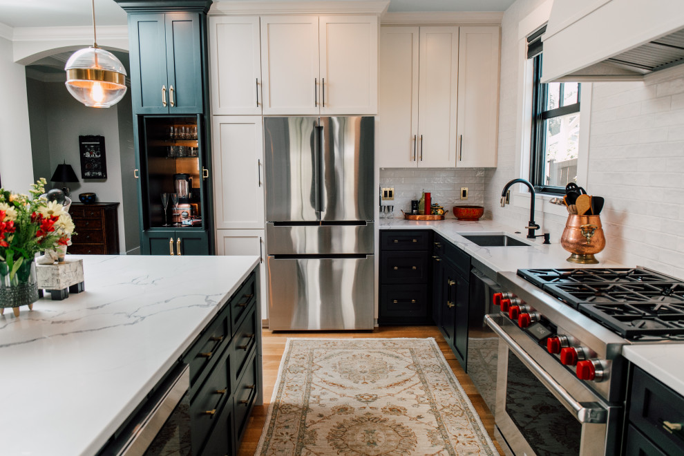 Inspiration for a mid-sized eclectic l-shaped open plan kitchen in Seattle with an undermount sink, shaker cabinets, green cabinets, quartz benchtops, white splashback, cement tile splashback, stainless steel appliances, light hardwood floors, with island, brown floor and white benchtop.