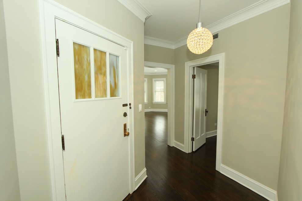 Front door - small transitional dark wood floor and brown floor front door idea in Chicago with beige walls and a white front door
