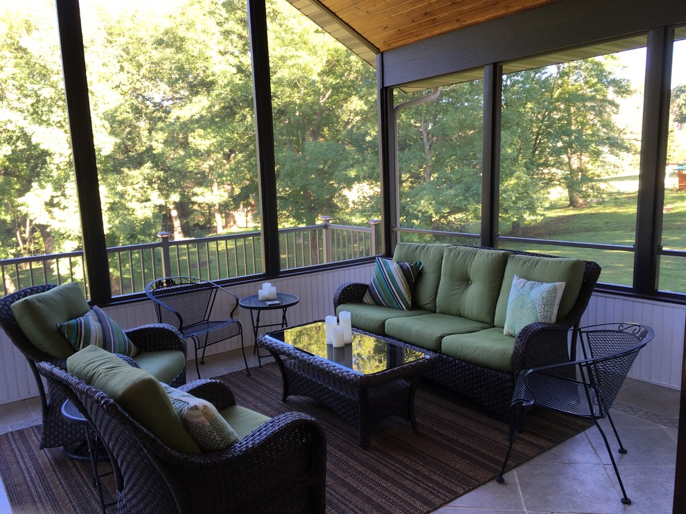 Photo of a mid-sized midcentury backyard screened-in verandah in Cedar Rapids with tile and a roof extension.