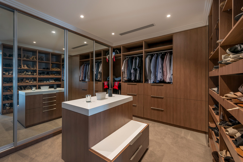 Design ideas for a contemporary gender-neutral dressing room in Perth with flat-panel cabinets, medium wood cabinets, carpet and beige floor.