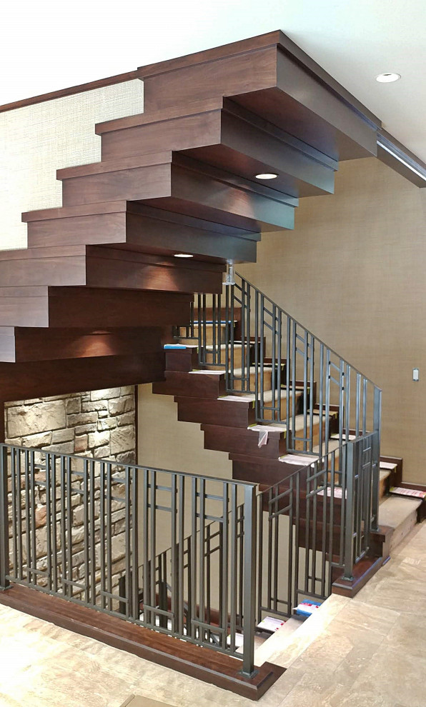 Photo of a carpeted u-shaped staircase in Kansas City with carpet risers, metal railing and wallpaper.