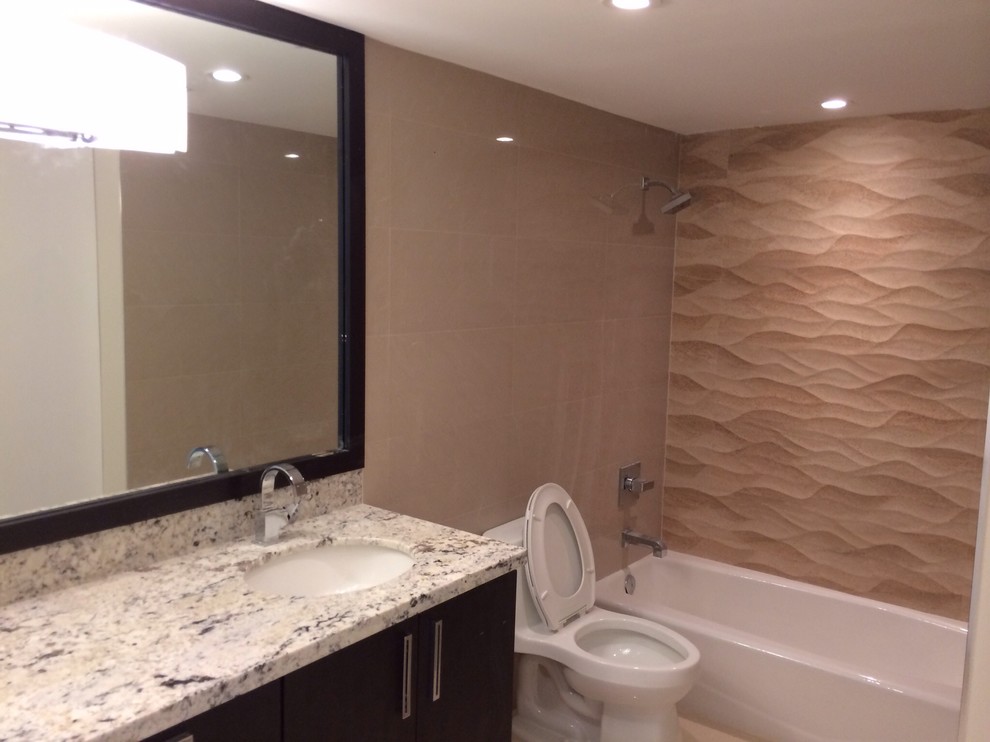 Accent wall in shower reminiscent of ocean waves. Mirror with wood frame to matc