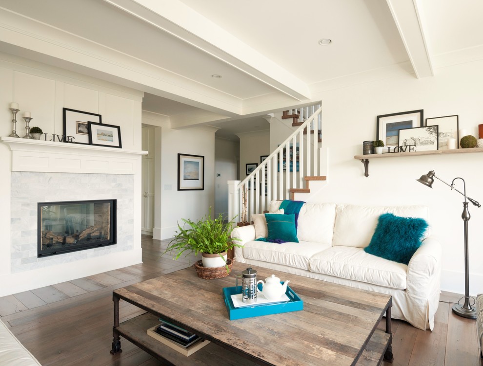 Inspiration for a large traditional open concept living room in Vancouver with white walls, medium hardwood floors, a two-sided fireplace and a stone fireplace surround.