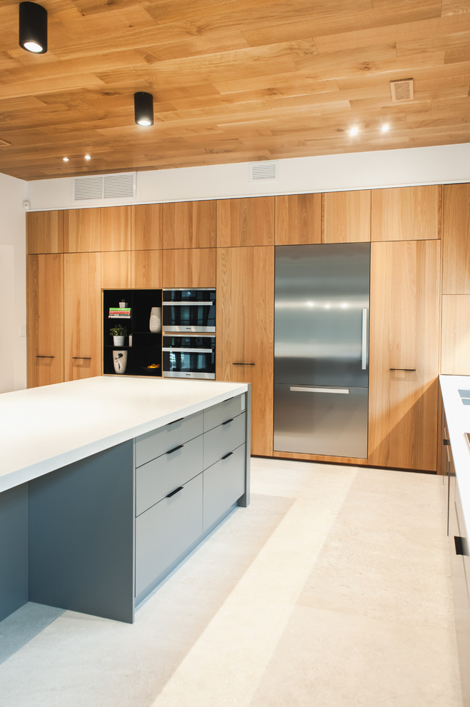 Photo of a contemporary l-shaped kitchen in Toronto with an undermount sink, flat-panel cabinets, quartzite benchtops, white splashback, stainless steel appliances, travertine floors, with island and white floor.