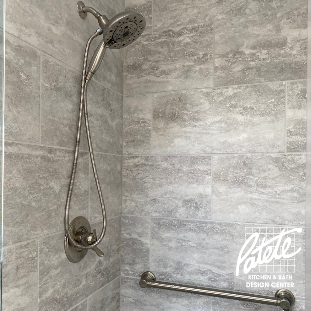 Ispirazione per una stanza da bagno american style con piastrelle grigie, piastrelle in pietra, porta doccia a battente e doccia ad angolo