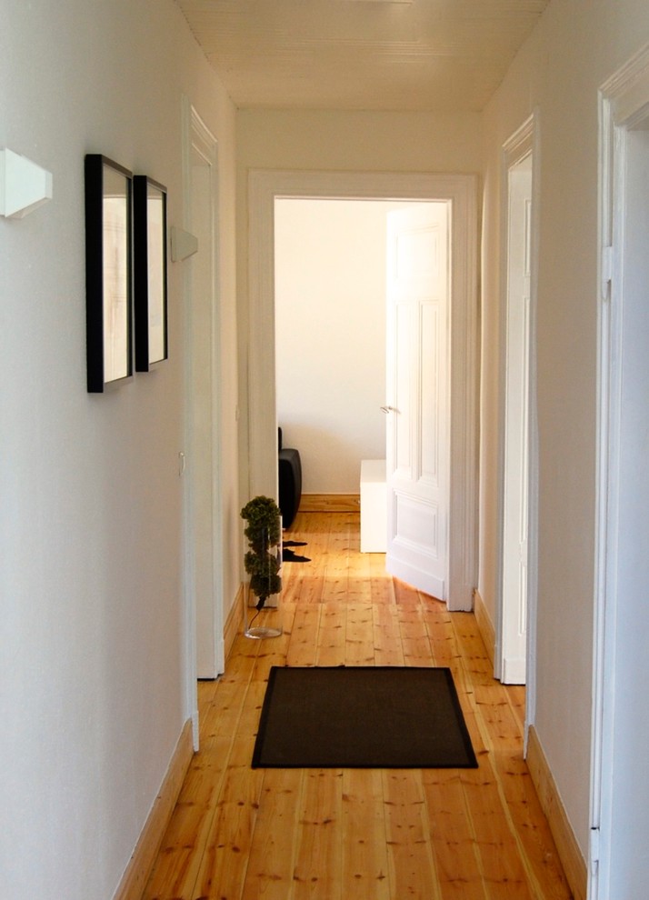 Mid-sized traditional hallway in Dortmund with white walls and light hardwood floors.