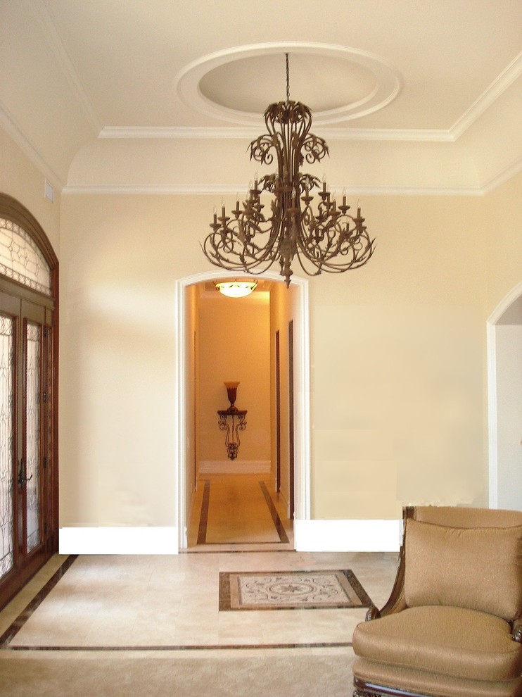 Photo of a large mediterranean foyer in Los Angeles with yellow walls, a double front door, a glass front door, porcelain floors, beige floor and coffered.