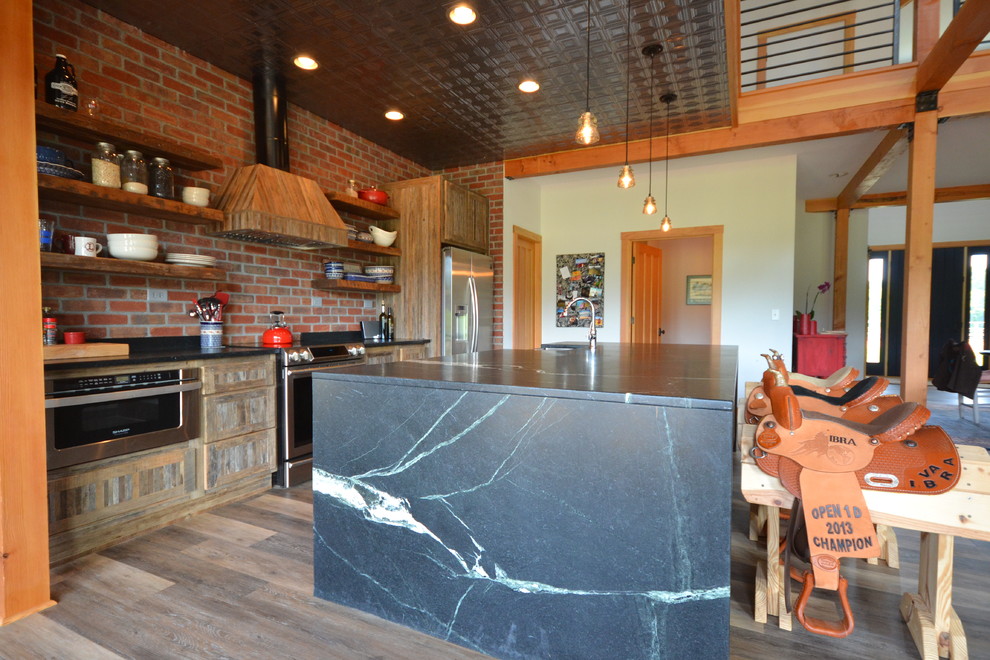 Kitchen - large rustic single-wall vinyl floor and brown floor kitchen idea with open cabinets, medium tone wood cabinets, soapstone countertops, an island, a farmhouse sink, red backsplash, brick backsplash and stainless steel appliances