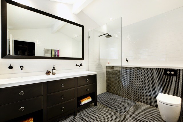This is an example of a contemporary master bathroom in Sydney with furniture-like cabinets, black cabinets, an open shower, a wall-mount toilet, black tile, white walls and ceramic tile.