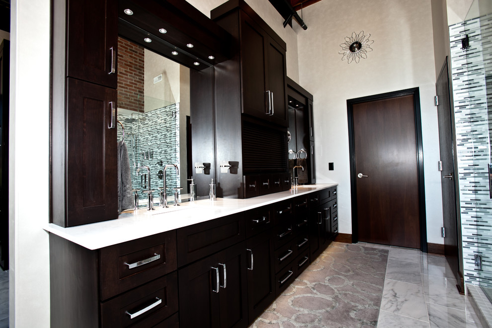 Photo of an industrial bathroom in St Louis with recessed-panel cabinets, dark wood cabinets, a freestanding tub and a corner shower.