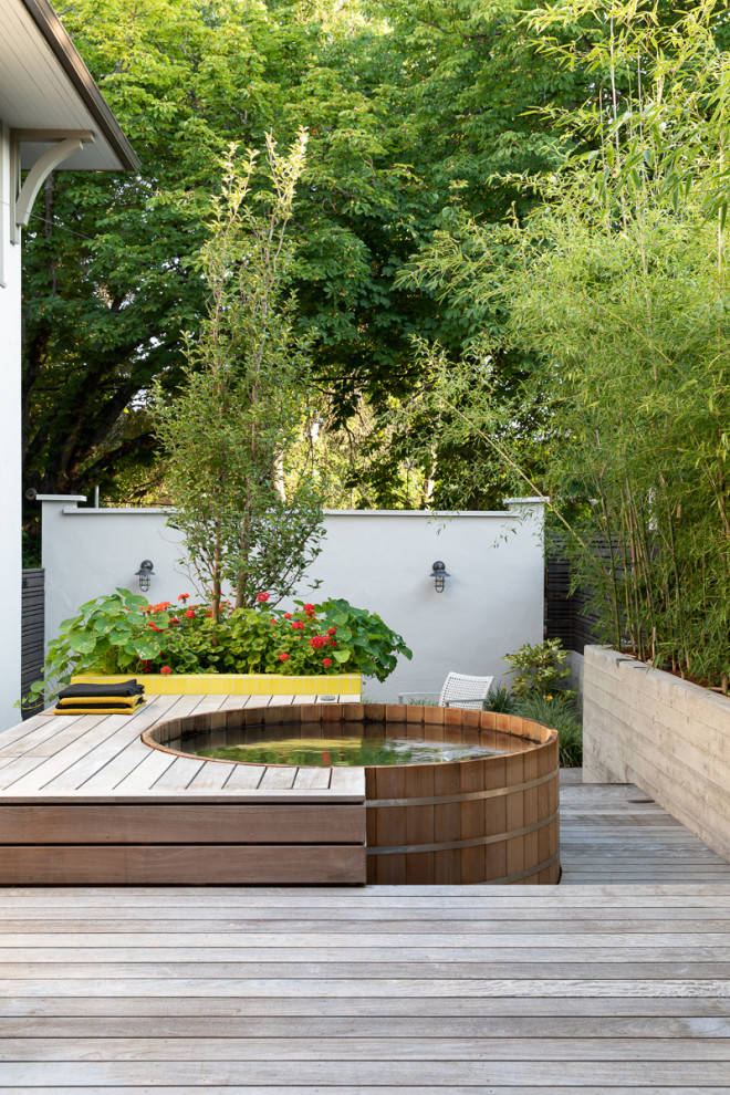 This is an example of a small modern backyard and ground level deck in Portland with an outdoor shower and no cover.