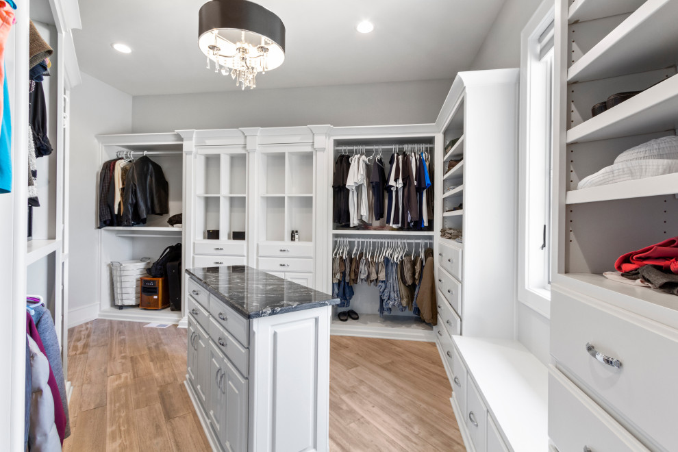 Large gender-neutral light wood floor and brown floor walk-in closet photo in Raleigh with raised-panel cabinets and white cabinets