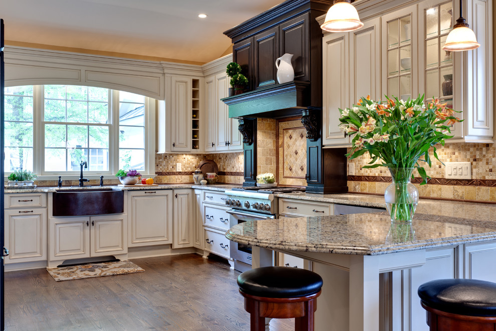 Large traditional u-shaped eat-in kitchen in Atlanta with raised-panel cabinets, stainless steel appliances, a farmhouse sink, white cabinets, granite benchtops, multi-coloured splashback, stone tile splashback, medium hardwood floors, a peninsula, brown floor and beige benchtop.
