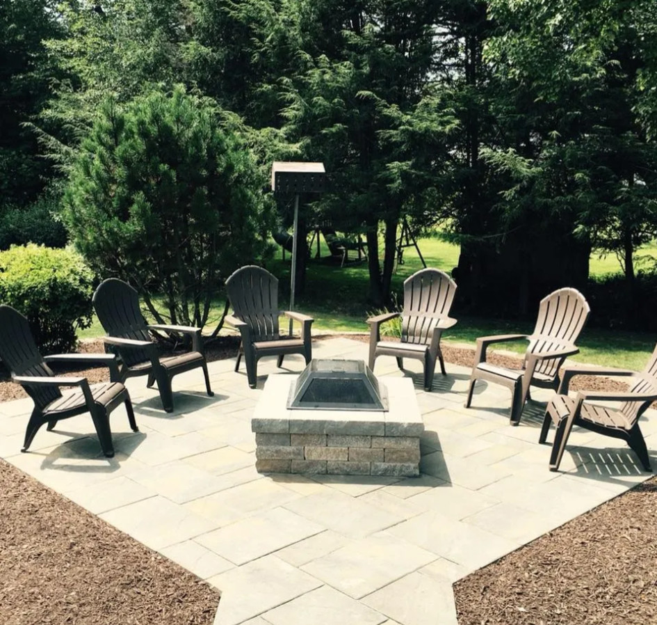 This is an example of a mid-sized transitional backyard patio in Bridgeport with a fire feature, concrete pavers and no cover.