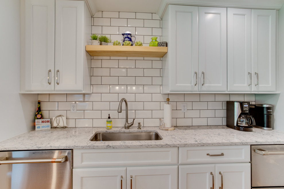 Inspiration for a large transitional l-shaped eat-in kitchen in Baltimore with an undermount sink, recessed-panel cabinets, quartz benchtops, white splashback, subway tile splashback, stainless steel appliances and with island.