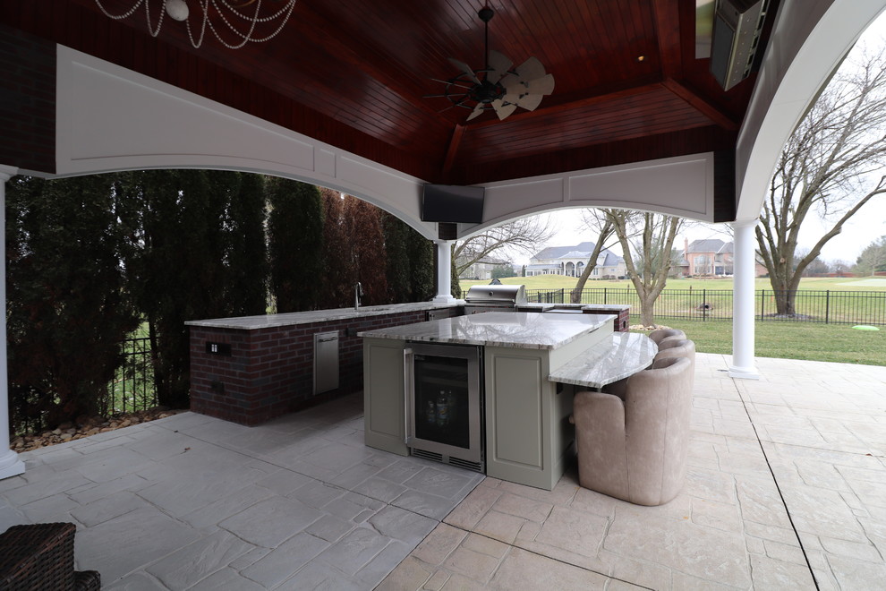 Large traditional backyard patio in Other with with fireplace, stamped concrete and a gazebo/cabana.