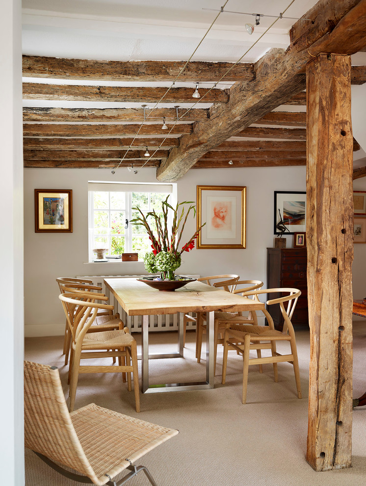This is an example of a country dining room in Other with white walls and carpet.