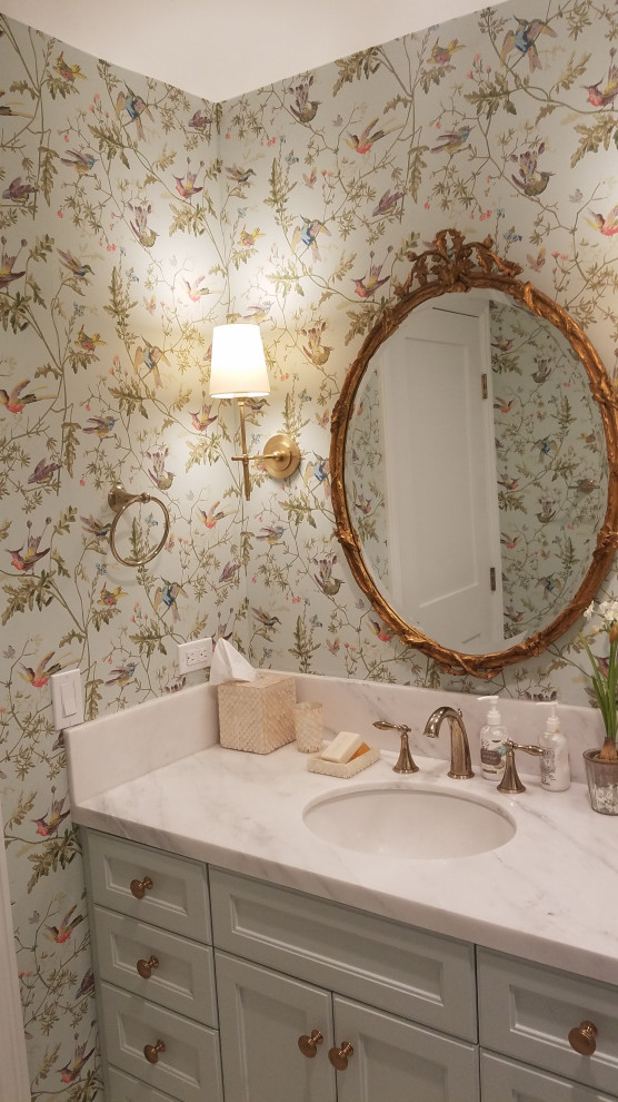This is an example of a traditional powder room in Orange County with wallpaper.