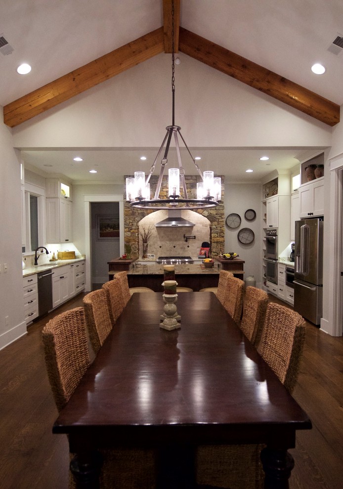 Kitchen/dining room combo - large rustic medium tone wood floor kitchen/dining room combo idea with a standard fireplace and a stone fireplace