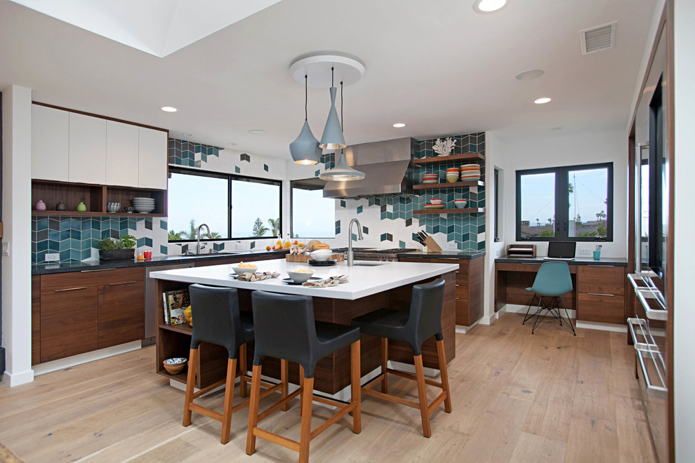 Contemporary u-shaped kitchen in San Diego with an undermount sink, flat-panel cabinets, dark wood cabinets, multi-coloured splashback, stainless steel appliances, medium hardwood floors, with island, brown floor and black benchtop.