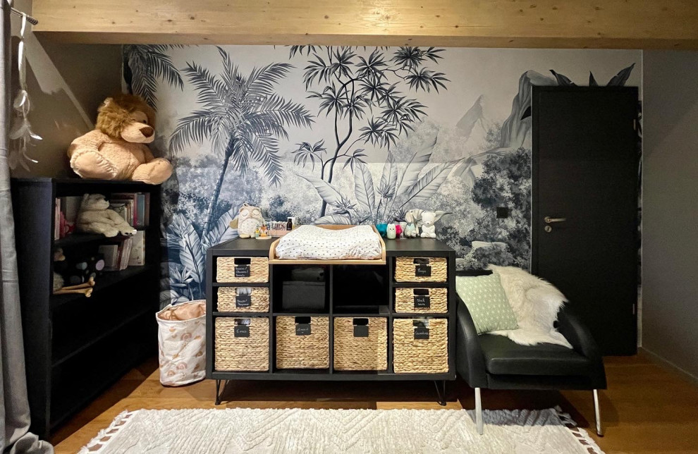Imagen de habitación de bebé niña tropical de tamaño medio con paredes beige, suelo de madera oscura, suelo marrón, madera y papel pintado