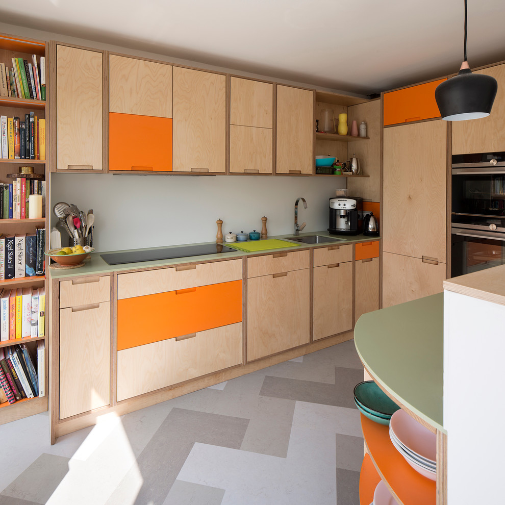 This is an example of a small contemporary u-shaped kitchen in Sussex with an integrated sink, flat-panel cabinets, light wood cabinets, solid surface benchtops, panelled appliances, linoleum floors and with island.