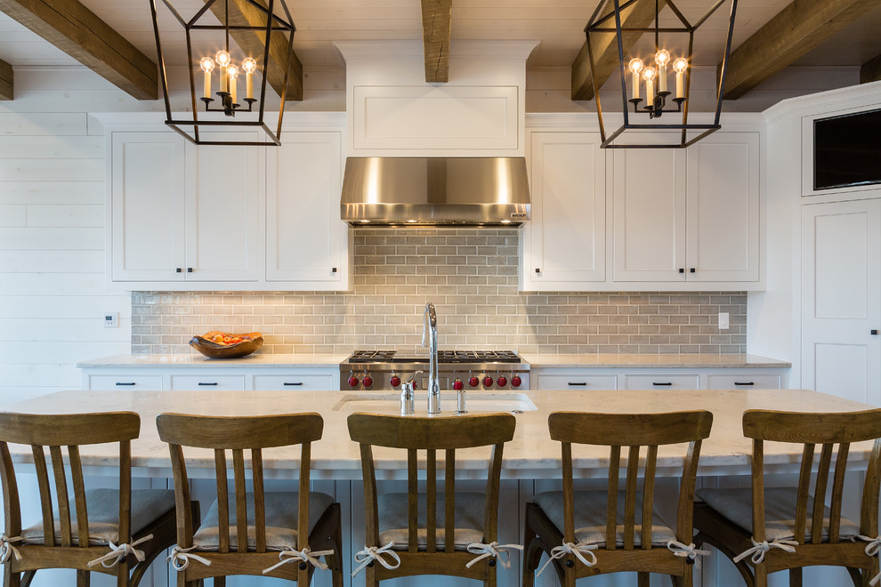 Large mountain style galley eat-in kitchen photo with an undermount sink, white cabinets, granite countertops, gray backsplash, porcelain backsplash, stainless steel appliances, an island and recessed-panel cabinets