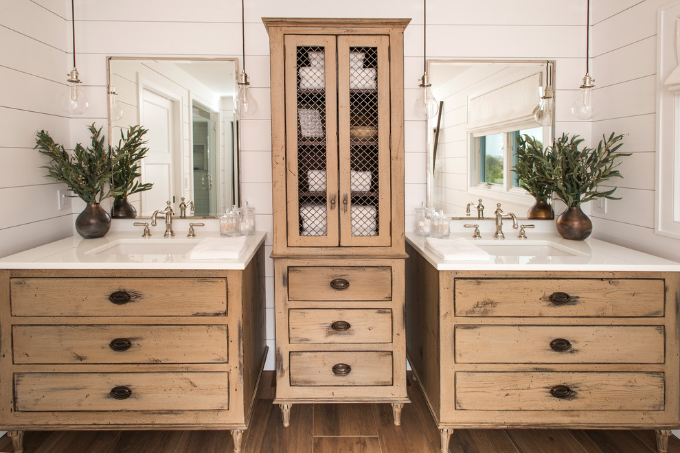 Large country master bathroom in Philadelphia with white walls, an undermount sink, brown floor, a freestanding tub, a one-piece toilet, white tile, ceramic floors, engineered quartz benchtops, light wood cabinets and flat-panel cabinets.