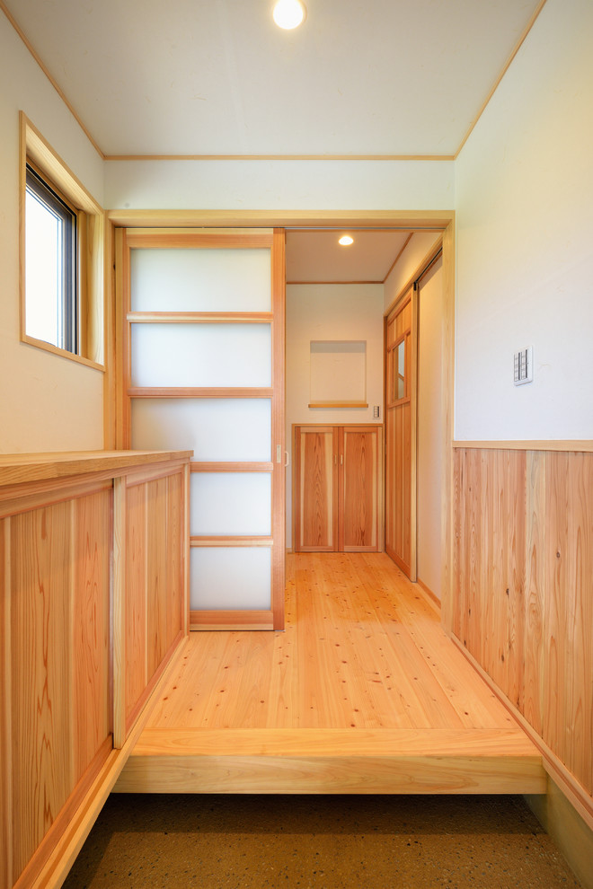 This is an example of a mid-sized asian entry hall in Other with light hardwood floors and a single front door.