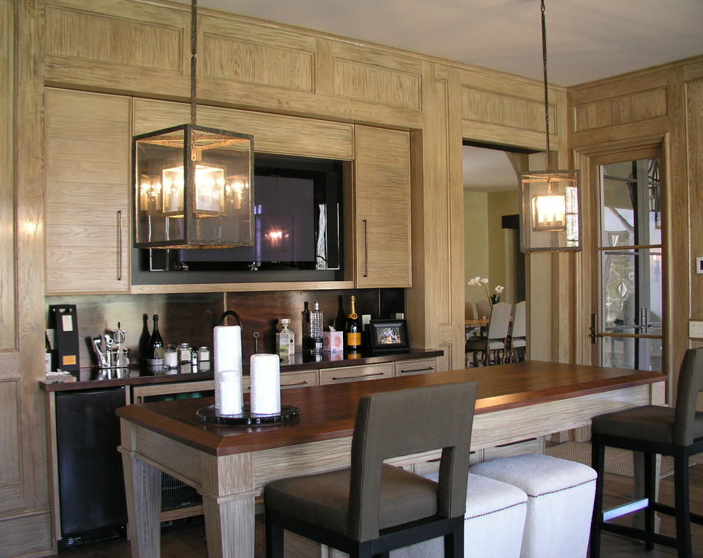 Photo of a large traditional galley seated home bar in Nashville with flat-panel cabinets, light wood cabinets, copper benchtops, brown splashback and dark hardwood floors.