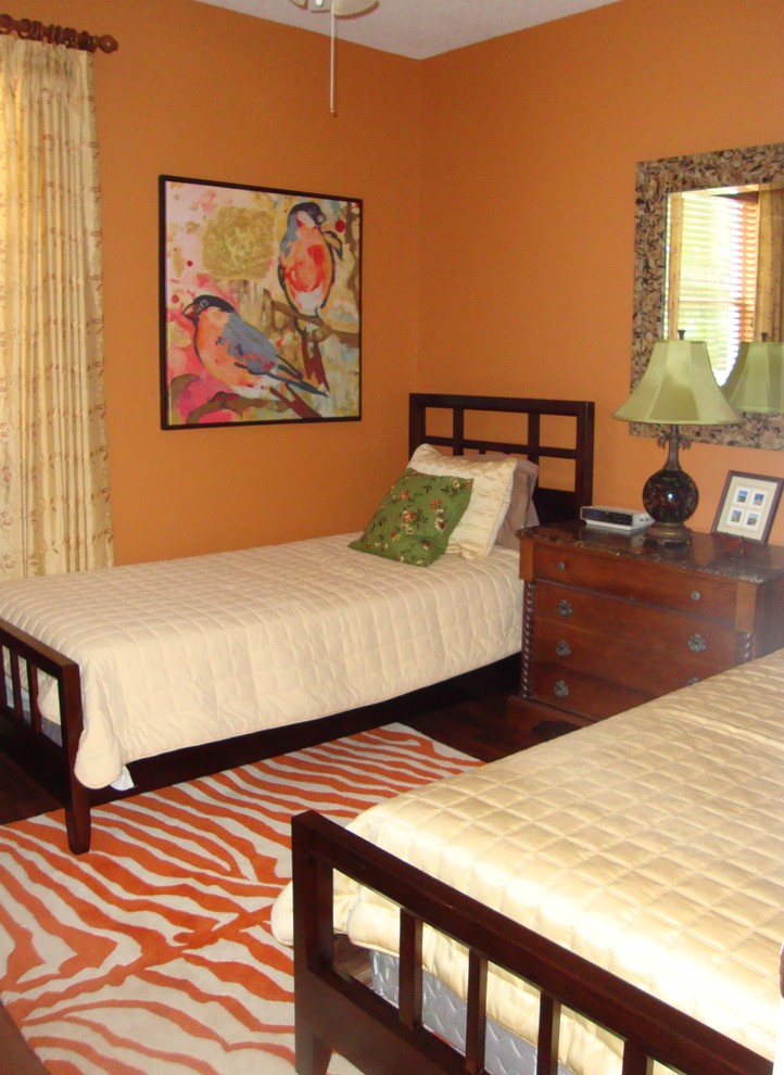 Bedroom - eclectic guest medium tone wood floor bedroom idea in Miami with orange walls