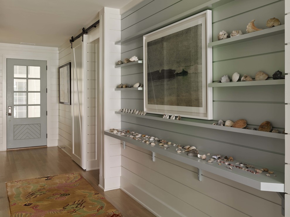 Design ideas for a large beach style hallway in Wilmington with light hardwood floors and white walls.