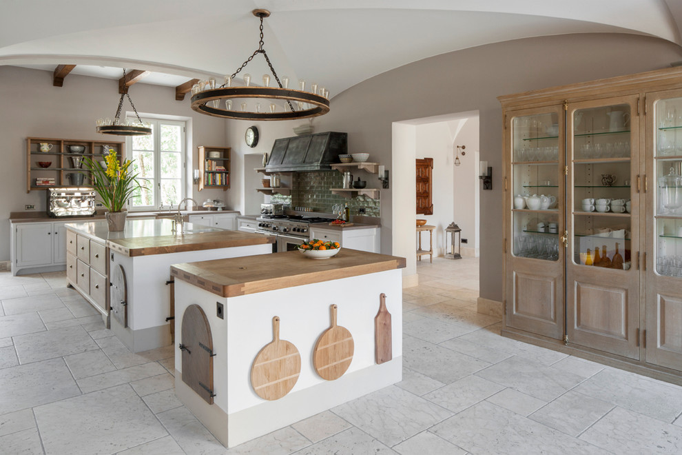 Design ideas for a large country u-shaped eat-in kitchen in London with light wood cabinets, marble benchtops, green splashback, subway tile splashback, stainless steel appliances, limestone floors and multiple islands.