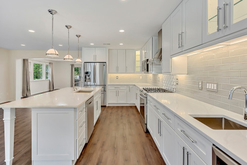 Spacious white Kitchen Cabinet Mississauga design with a large center island and stainless steel appliances, illustrating the high-end look achievable with affordable RTA options