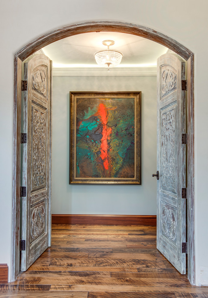 This is an example of a mid-sized mediterranean hallway in Los Angeles with grey walls and medium hardwood floors.