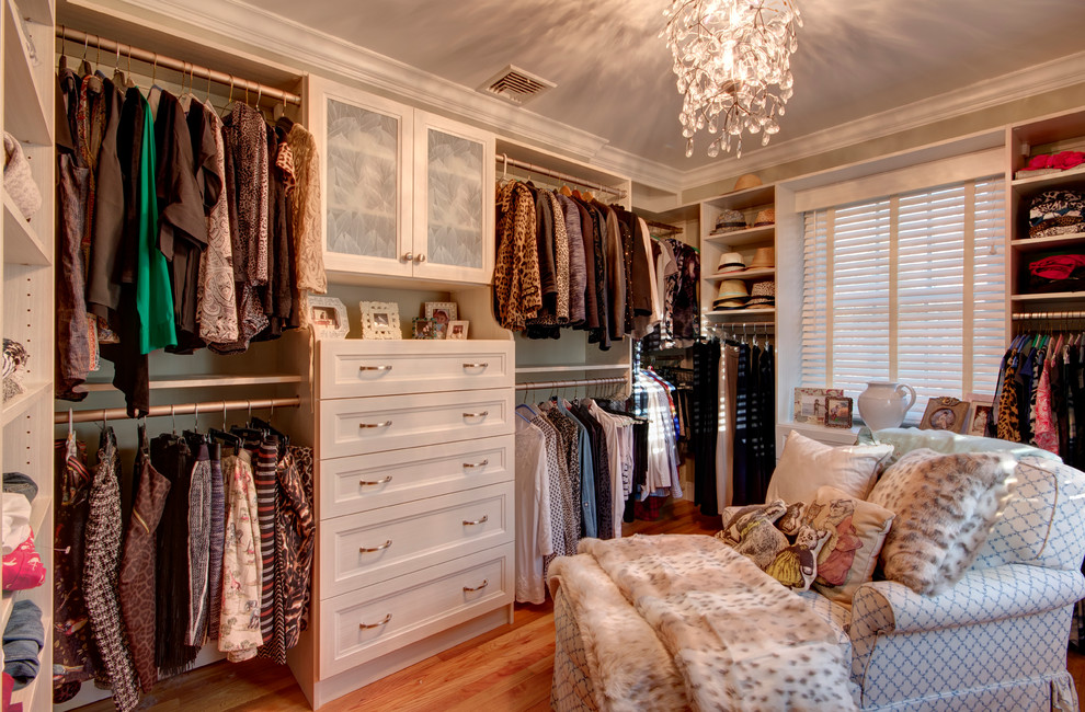 Photo of a large traditional women's walk-in wardrobe in Other with light hardwood floors, beige floor, recessed-panel cabinets and light wood cabinets.