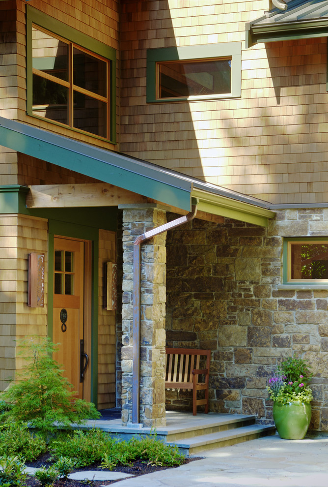 This is an example of a country entryway in Seattle with a single front door and a light wood front door.