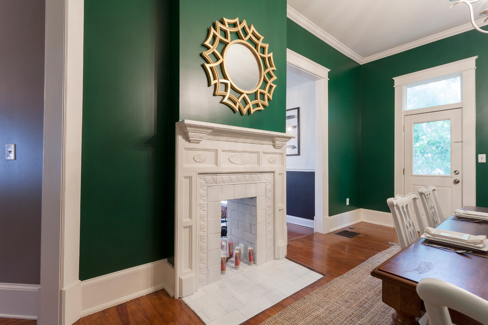 Photo of a small eclectic separate dining room in Nashville with green walls, medium hardwood floors, a standard fireplace and a tile fireplace surround.