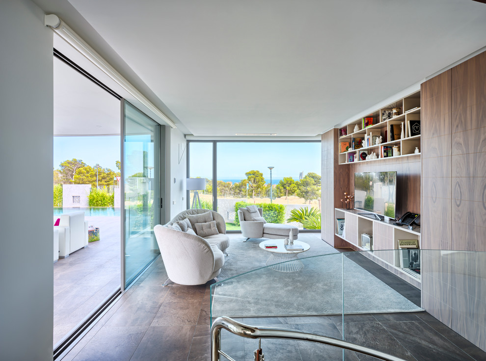 Mid-sized contemporary open concept family room in Alicante-Costa Blanca with a library, white walls, no fireplace and a built-in media wall.