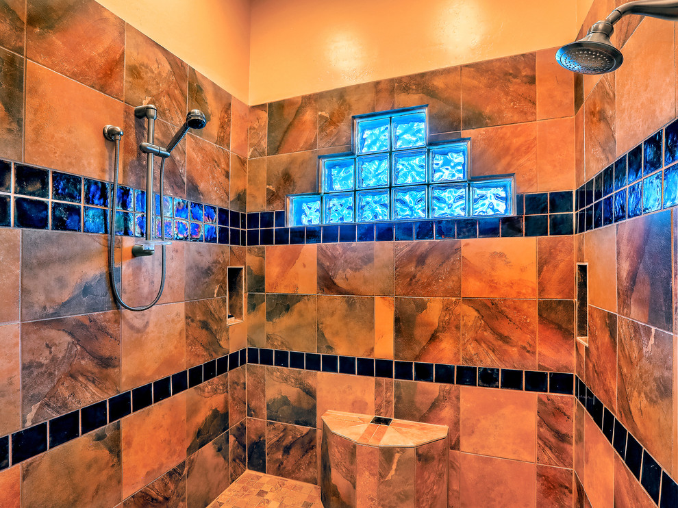 Large master bathroom in Albuquerque with flat-panel cabinets, medium wood cabinets, a drop-in tub, an open shower, a one-piece toilet, multi-coloured tile, ceramic tile, beige walls, travertine floors, an undermount sink, granite benchtops, beige floor and an open shower.