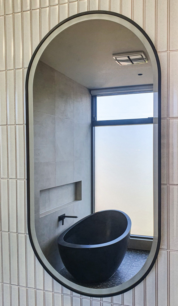 This is an example of a large contemporary master bathroom in Melbourne with black cabinets, a freestanding tub, beige tile, ceramic tile, terrazzo floors, concrete benchtops, black floor, a niche, a double vanity and a floating vanity.