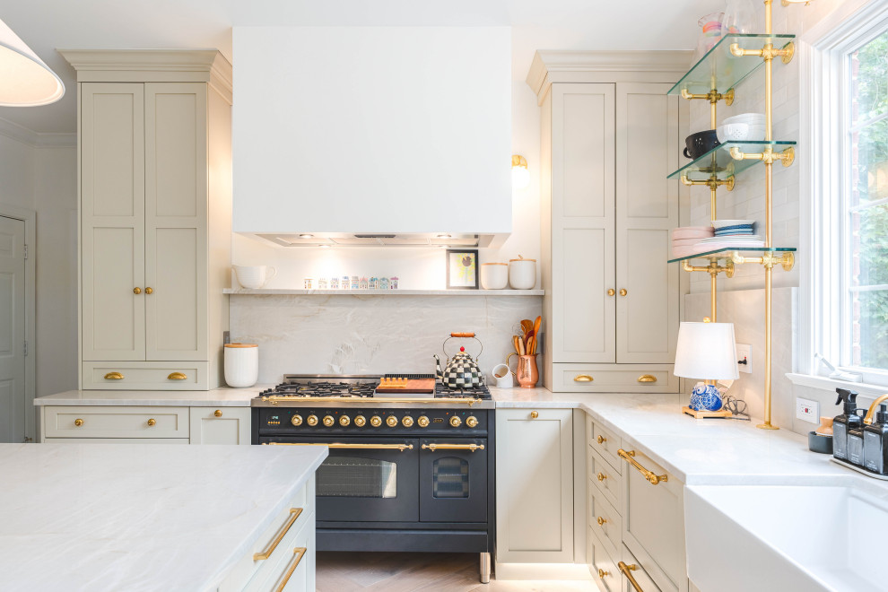 Example of a large french country u-shaped light wood floor and beige floor enclosed kitchen design in DC Metro with a farmhouse sink, shaker cabinets, white cabinets, quartzite countertops, white backsplash, quartz backsplash, white appliances, an island and beige countertops