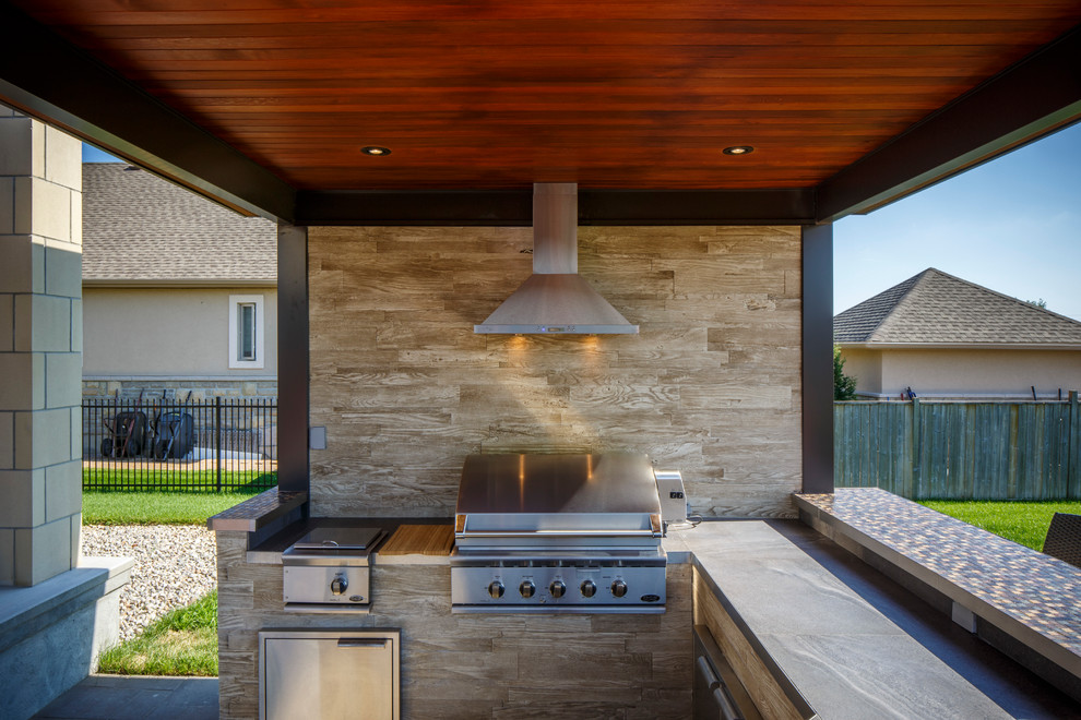 This is an example of a transitional backyard patio in Detroit with an outdoor kitchen.
