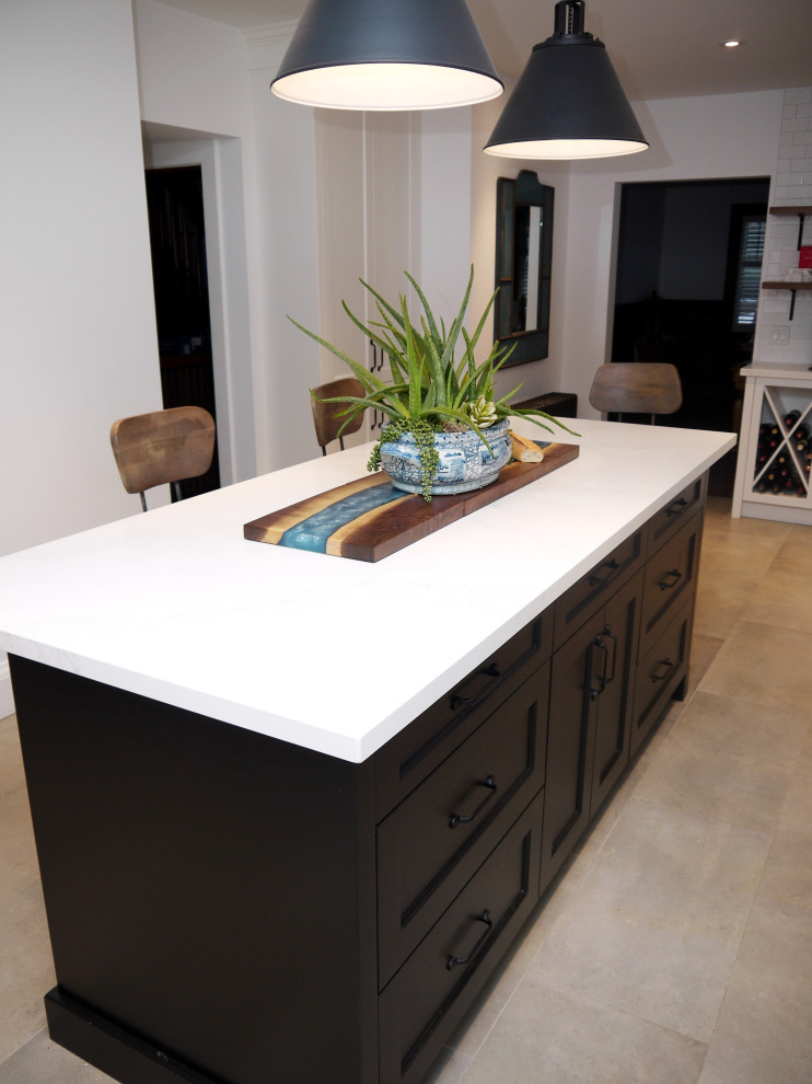 Inspiration for a mid-sized transitional l-shaped porcelain tile and gray floor enclosed kitchen remodel in Toronto with a farmhouse sink, recessed-panel cabinets, white cabinets, quartz countertops, white backsplash, porcelain backsplash, stainless steel appliances, an island and white countertops