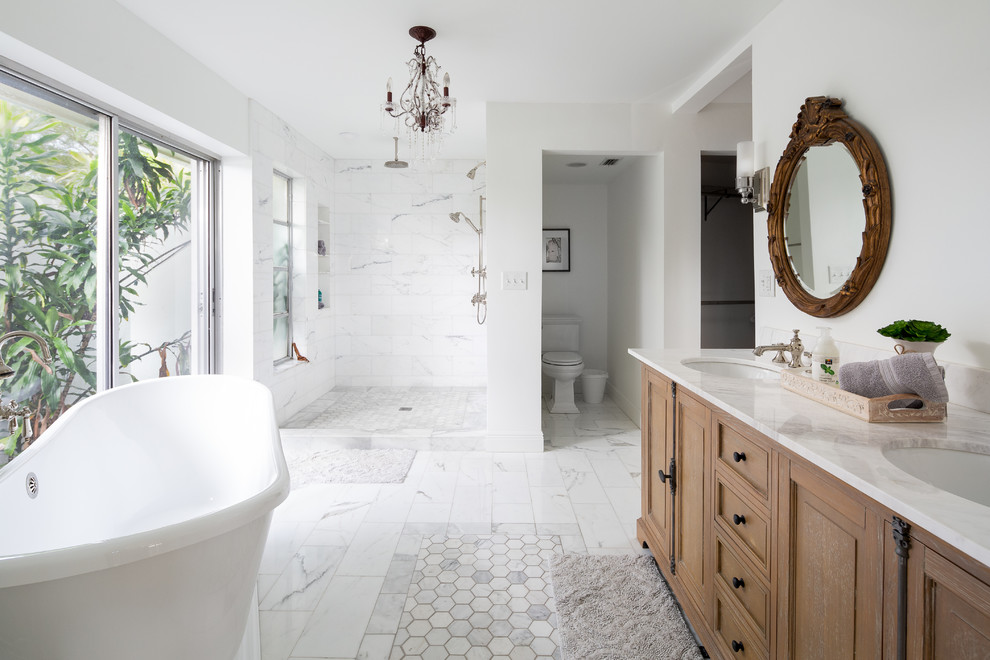 Transitional bathroom in Miami with raised-panel cabinets, medium wood cabinets, a freestanding tub, an alcove shower, white tile, white walls, an undermount sink, white floor, an open shower and white benchtops.