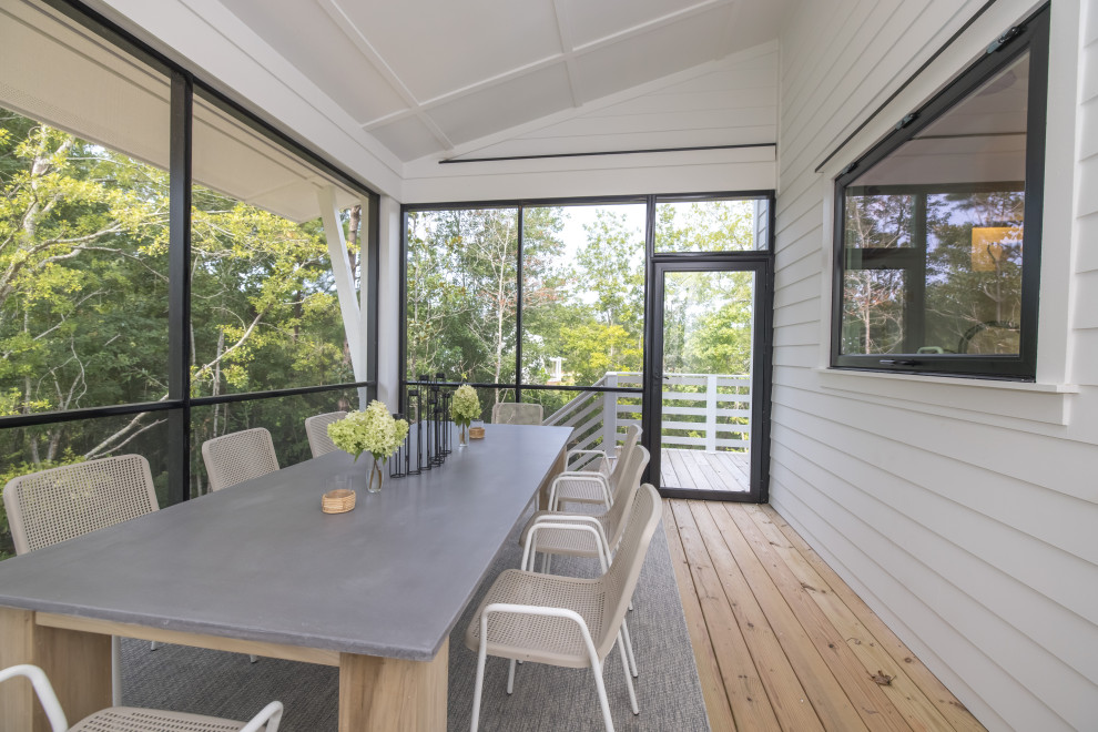 Idées déco pour un porche d'entrée de maison arrière moderne avec une moustiquaire, une terrasse en bois, une extension de toiture et un garde-corps en bois.
