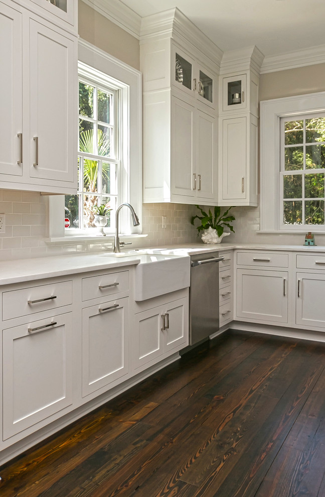 Photo of a traditional kitchen in Charleston with a farmhouse sink, shaker cabinets, white cabinets, grey splashback, subway tile splashback and dark hardwood floors.