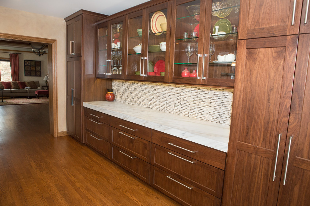 Example of a huge transitional l-shaped medium tone wood floor enclosed kitchen design in Chicago with an undermount sink, flat-panel cabinets, medium tone wood cabinets, marble countertops, white backsplash, stone slab backsplash, stainless steel appliances and an island