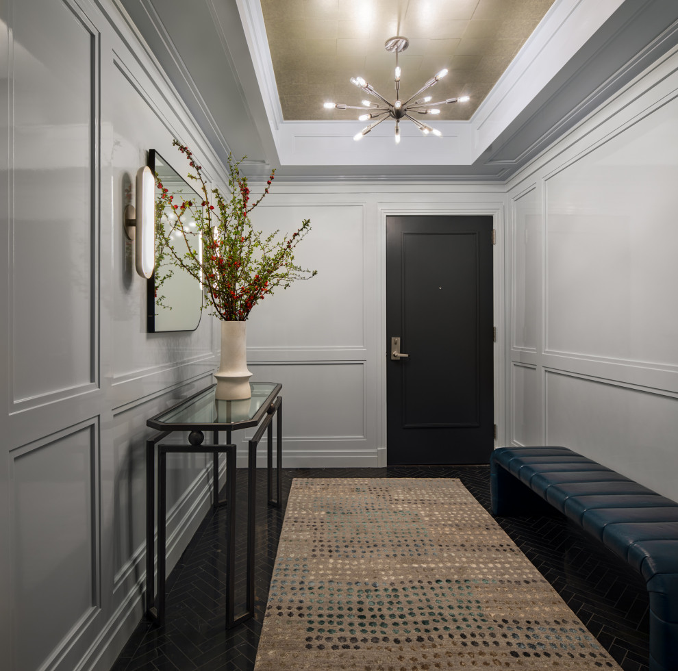 Cette image montre une entrée minimaliste avec un sol en marbre, un plafond décaissé et boiseries.
