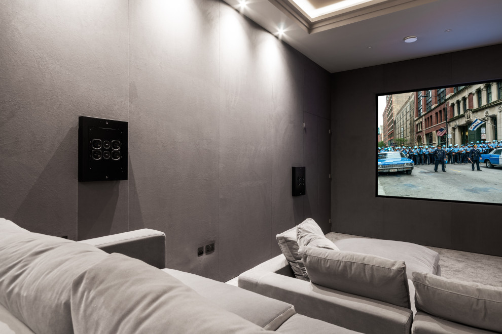 Modelo de cine en casa cerrado contemporáneo grande con paredes grises, moqueta, pantalla de proyección y suelo gris